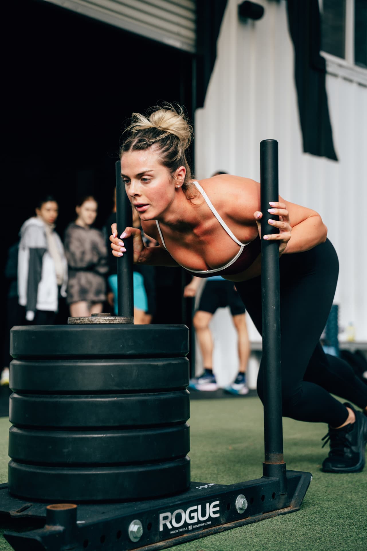 Athlete pushing a sled inside the Urban Athletics gym